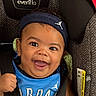 baby, blue_jersey, car_seat, child, closeup, clothing, cute, expression, face, happy, headband, headwear, indoors, infant, joyful, person, portrait, seatbelt, smiling, young_child