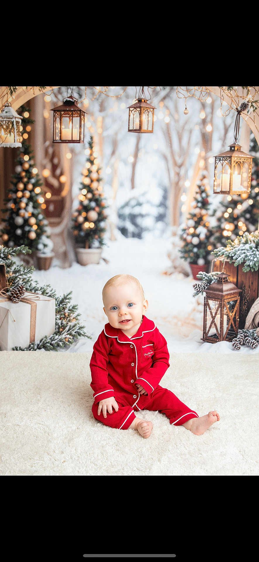Tommy is registered to the contest to win money with this photo: baby, child, red_pajamas, smiling, sitting, white_rug, christmas_trees, lanterns, holiday, winter, snow, decorations, presents, festive, indoors, cute, portrait, happy, bright, seasonal