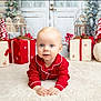 Tommy is registered to the contest to win money with this photo: baby, child, red_pajamas, christmas, holiday, festive, decorations, gifts, carpet, white, indoor, portrait, cute, holiday_season, winter, lantern, pine_tree, present, smiling, toddler