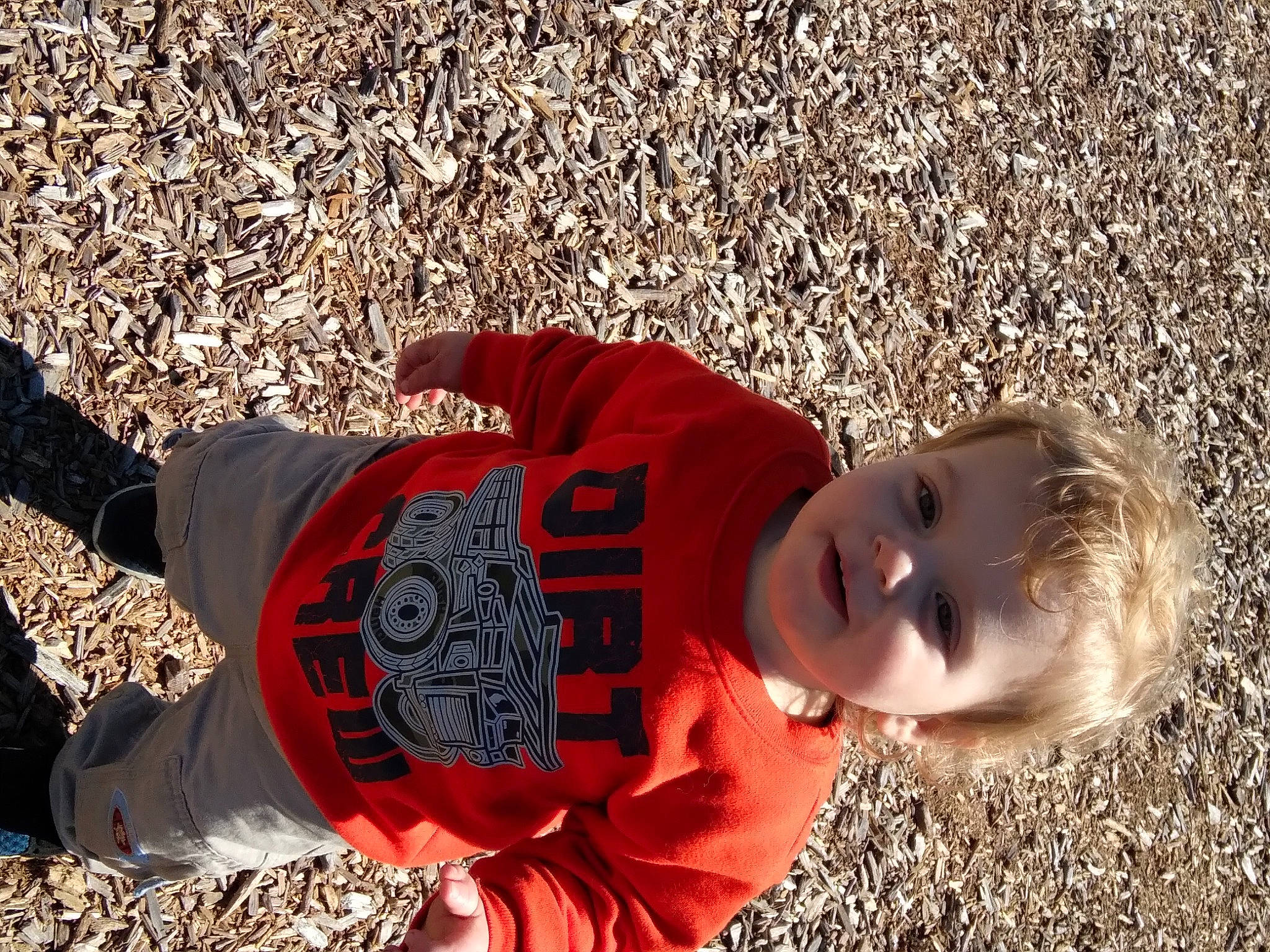 Killian joined the competition — help win amazing prizes! baby, child, fun, grass, happy, hat, leisure, orange, pattern, people_in_nature, person, sand, shadow, sitting, sleeve, smile, soil, t_shirt, toddler, wood
