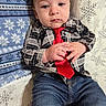 Braxton is registered to the contest to win money with this photo: baby, blanket, casual_clothing, child, closeup, cozy, cute, expression, face, hands, indoor, infant, jeans, person, plaid_shirt, portrait, red_tie, sitting, snowflake_pattern, young