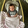 baby, baby_rocker, blanket, blue_eyes, carpet, child, clothing, comfort, cute, face, hair, indoor, infant, newborn, nirvana_tshirt, pacifier, plush_toy, relaxing, resting, soft_toy