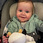 Jace joined the competition — help win amazing prizes! baby, child, infant, smiling, face, plush_toy, cow_toy, jacket, car_seat, seatbelt, comfort, cute, happy, portrait, indoors, young_child, soft_lighting, rosy_cheeks, clothing, hand