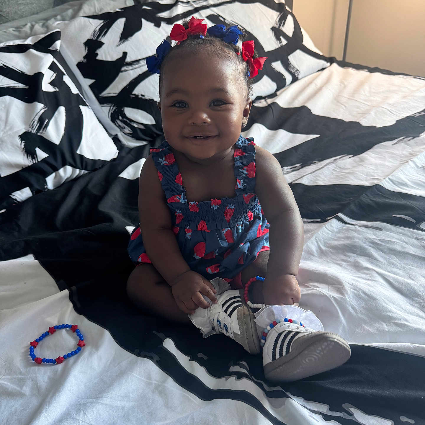 Sanai joined the competition — help win amazing prizes! accessory, baby, bed, blanket, bracelet, child, clothing, cute, footwear, hair_bow, happy, head, indoor, infant, pattern, person, portrait, shoe, sitting, smiling