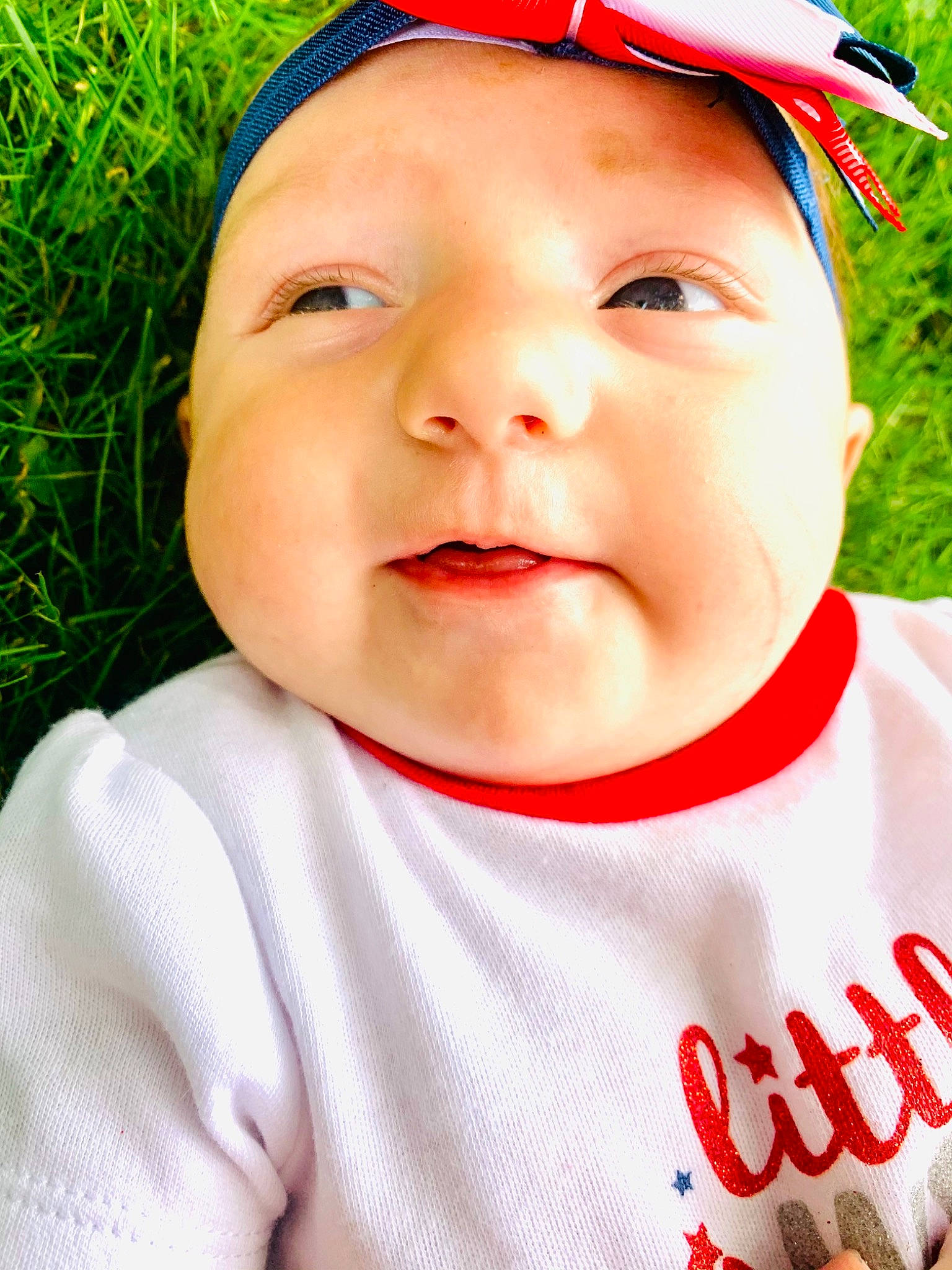 Anna is registered to the contest to win money with this photo: baby_toddler_clothing, cap, cheek, chin, cool, eye, eyebrow, face, forehead, grass, green, happy, lip, nose, organ, person, photograph, pink, skin, sleeve