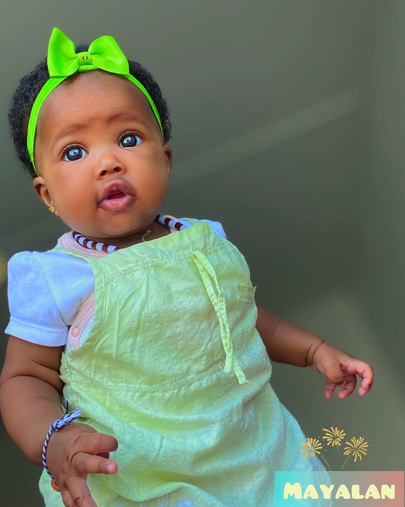 Mayalan a rejoint le concours — aidez-le/la à gagner de superbes lots ! baby, baby_toddler_clothing, cap, cheek, child, costume_hat, dress, eyelash, fashion_accessory, fun, green, hair_accessory, happy, iris, jewellery, magenta, pattern, person, sitting, sleeve