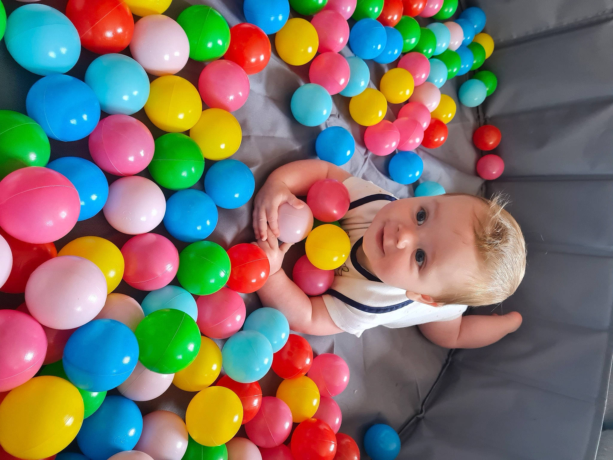 Garrett is registered to the contest to win money with this photo: baby, baby_playing_with_toys, baby_products, baby_toddler_clothing, ball, ball_pit, balloon, child, confectionery, event, food, fun, leisure, party, party_supply, person, play, sweetness, toddler, toy