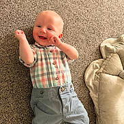 Noah joined the competition — help win amazing prizes! baby, infant, child, smiling, happy, portrait, lying_down, carpet, blanket, plaid_shirt, trousers, clothing, indoor, home, cozy, playful, face, arms, baby_fashion, photography