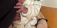 Pippa is registered to the contest to win money with this photo: newborn, baby, infant, person, arm, hand, clothing, onesie, stars, face, expression, skin, nails, pink_nails, fingers, holding, indoor, couch, wood, fabric