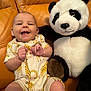 baby, child, comfort, couch, cozy, cute, giraffe_pattern, happy, indoor, infant, joyful, onesie, orange_couch, panda, plush_toy, portrait, seated, smile, soft_toy, young_child