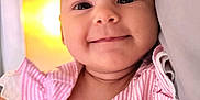 Pippa Elsie joined the competition — help win amazing prizes! baby, child, closeup, comfortable, cozy, cute, face, happy, indoors, infant, lying_down, pillow, pink_clothing, portrait, small_person, smiling, soft_texture, striped, warm_light, young_child