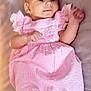 baby, bare_feet, calm, child, clothing, curious, cute, expression, face, indoors, infant, lying_down, newborn, person, pink_dress, portrait, small_feet, small_hands, soft_surface, striped_dress