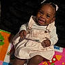 baby, child, infant, smiling, portrait, sitting, indoor, play_mat, colorful, dress, overalls, sneakers, hair_bows, dark_skin, happy, playroom, toy_mat, closeup, feet, casual
