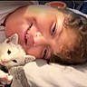 Snowball is registered to the contest to win money with this photo: child, kitten, white_cat, smiling, lying_down, bed, cozy, cute, pet, animal, face, happy, indoor, closeup, resting, young, soft, comfort, friendship, affection