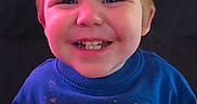 Edward joined the competition — help win amazing prizes! child, toddler, smiling, sweatshirt, blue_clothing, text_on_clothing, indoor, portrait, happy, face, person, casual_wear, cute, young_child, seated, home, lighting, colorful, expression, sitting