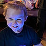 Edward is registered to the contest to win money with this photo: child, boy, smile, face, blue_light, toy, game, indoor, dark_background, black_shirt, short_hair, happy, playing, person, young, cute, fun, amusement, lighting, portrait