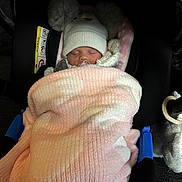 Arabella joined the competition — help win amazing prizes! baby, sleeping, blanket, car_seat, hat, cozy, infant, pacifier, child, cute, soft_lighting, pink, white, pom_poms, indoor, resting, warm, newborn, fabric, comfort