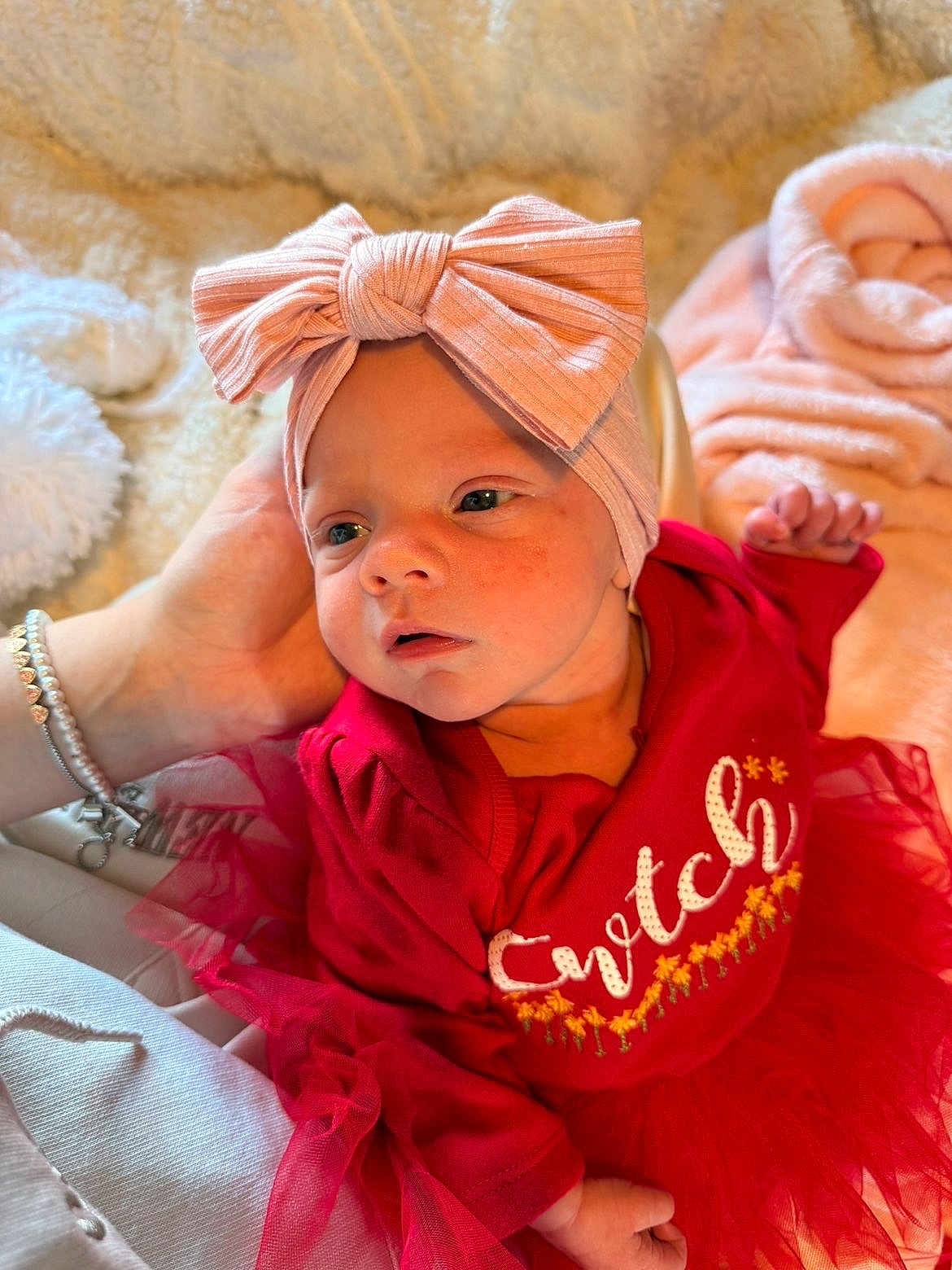 Arabella joined the competition — help win amazing prizes! baby, infant, child, headband, bow, red_clothing, tulle, hand, bracelet, blanket, soft_texture, portrait, cute, newborn, face, expression, indoors, resting, closeup, warm_light