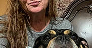 Nikki joined the competition — help win amazing prizes! woman, dog, indoor, portrait, long_hair, gray_shirt, brown_hair, headboard, curtain, face, pet, closeup, smile, expression, furniture, casual, home, resting, companion, candid