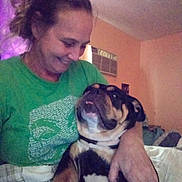 Nikki joined the competition — help win amazing prizes! woman, dog, indoor, smile, green_shirt, air_conditioner, affection, pet, love, home, casual, portrait, human, animal, brown, black, tan, face, hand, comfort