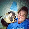 Nikki joined the competition — help win amazing prizes! dog, person, smiling, selfie, indoor, blue_shirt, pet, companion, face, lying_down, quilt, head_tilt, closeup, blurred, friendship, canine, casual, happy, relaxed, bond