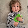 Alyanna joined the competition — help win amazing prizes! child, couch, cozy, cute, face, green, hair, hand, happy, indoor, pajamas, patterned_clothing, person, playful, plush_toy, sitting, smiling, soft_furnishing, toddler, toy