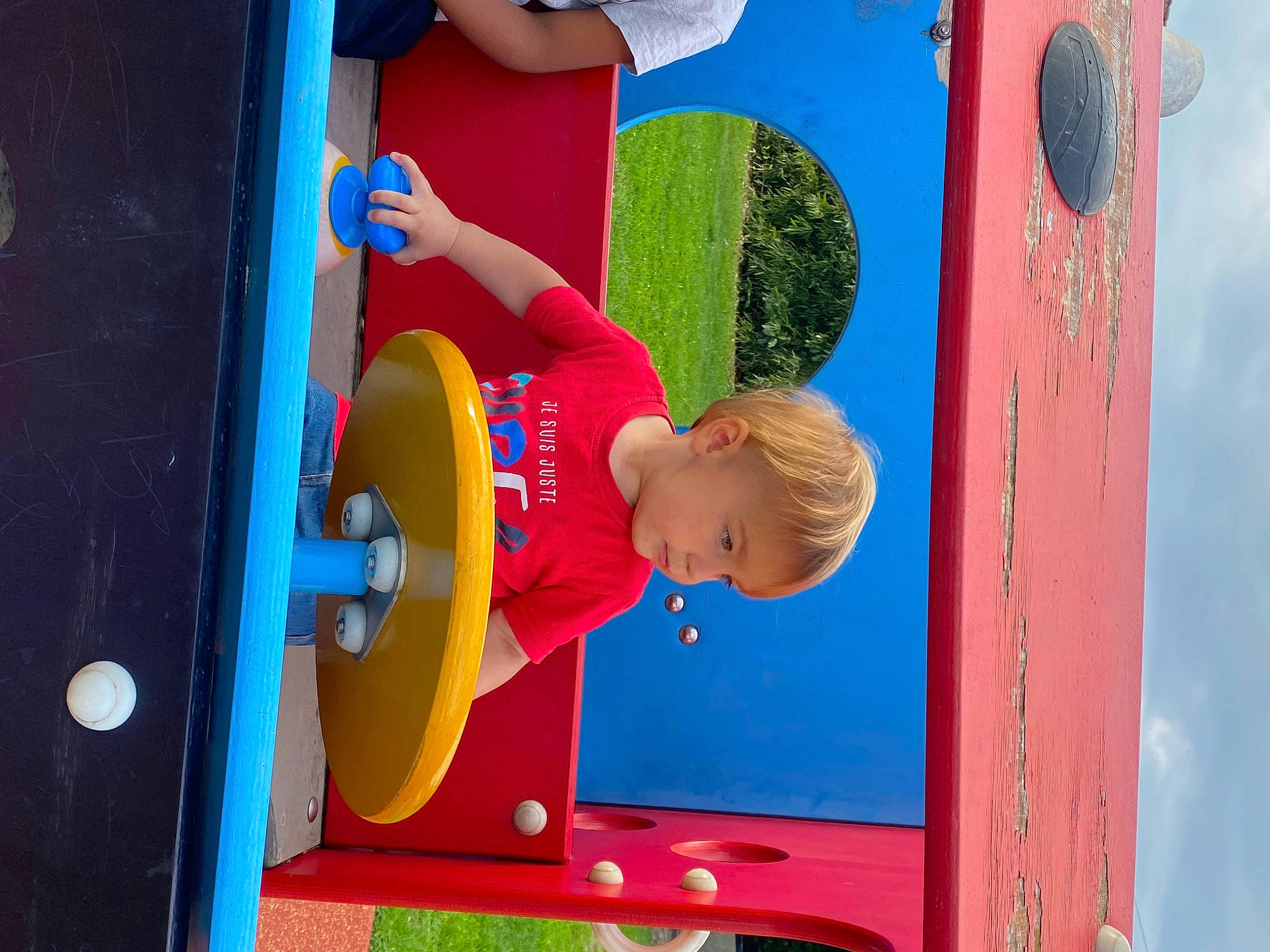 Noa participe au concours pour gagner de l'argent avec cette photo : art, azure, blue, city, electric_blue, fun, human_settlement, leisure, line, outdoor_play_equipment, person, playground, playground_slide, public_space, recreation, red, snapshot, summer, t_shirt, toddler