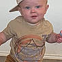 Jaxon joined the competition — help win amazing prizes! toddler, child, cap, hat, beige, blue_eyes, tshirt, brown_pants, lollipop, indoor, rug, floor, curious, cute, standing, young_child, person, casual_clothing, expression, home