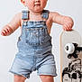 Jaxon is registered to the contest to win money with this photo: toddler, child, denim_overalls, barefoot, skateboard, skull_design, blue_eyes, red_hair, standing, white_background, cute, baby, portrait, one_person, casual_clothing, toy, playful, young_child, studio_photo, fashion