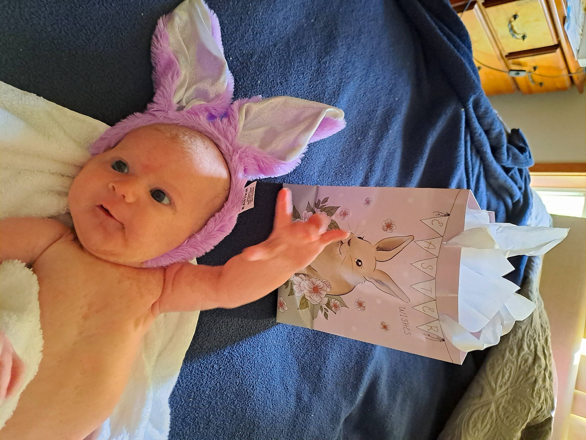 Imogen is registered to the contest to win money with this photo: baby, baby_products, baby_toddler_clothing, child, costume_hat, ear, fashion_accessory, finger, happy, headpiece, party_hat, party_supply, person, pink, plush, room, sleeve, smile, stuffed_toy, textile