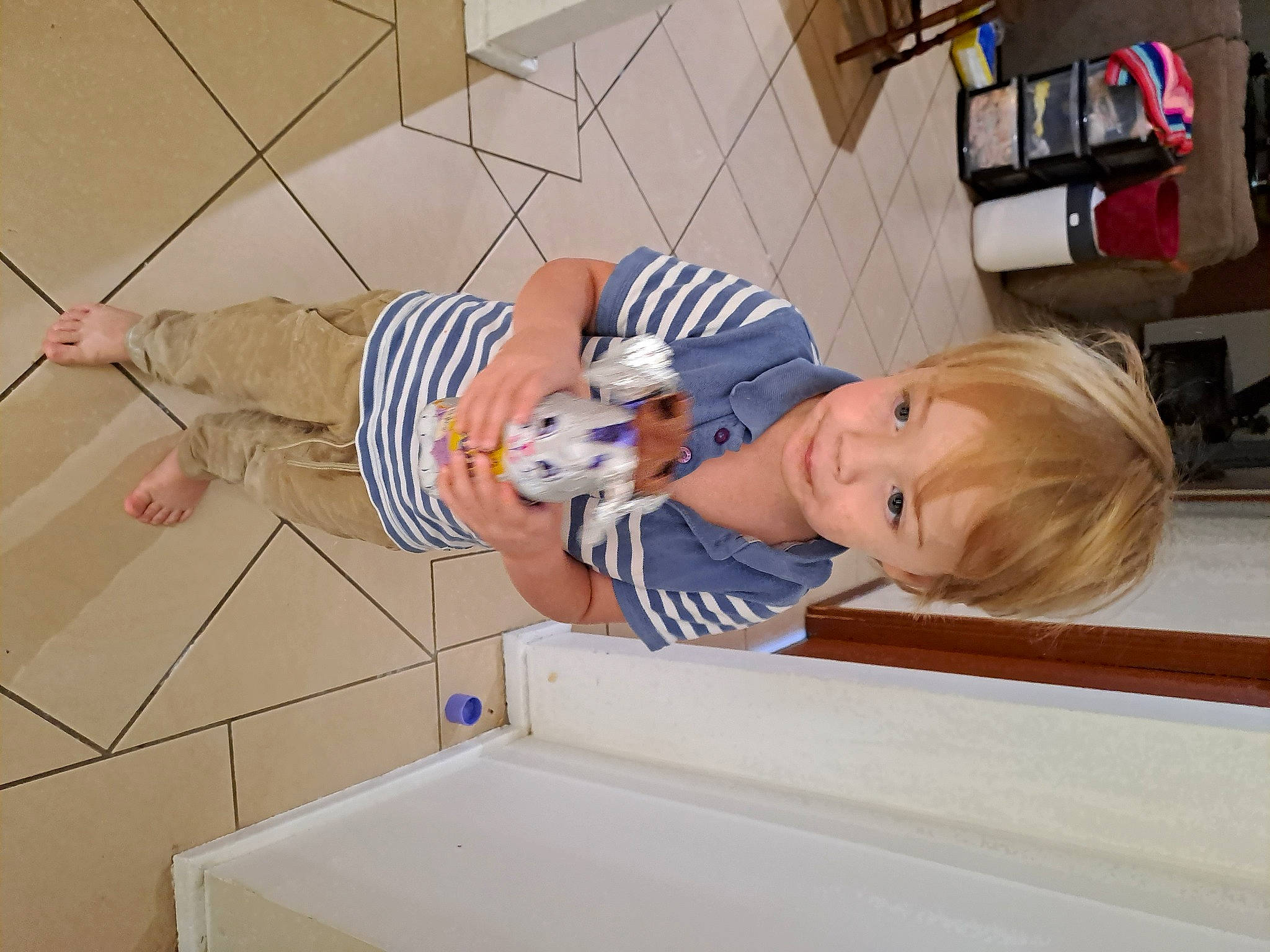 Owen is registered to the contest to win money with this photo: baby, baby_products, baby_toddler_clothing, child, comfort, elbow, flooring, person, room, smile, t_shirt, toddler, wood