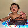birthday, cake, celebration, child, chocolate, curly_hair, expression, face, food, fun, hands, high_chair, indoor, messy, plate, sitting, smudge, sweet, toddler, young_child