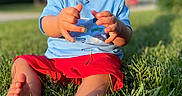 Braxton joined the competition — help win amazing prizes! barefoot, blue_shirt, child, curious, daylight, drool, grass, greenery, lawn, nature, outdoor, person, playing, portrait, red_shorts, sitting, summer, sunlight, toddler, young_child