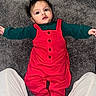 baby, infant, red_overall, green_sleeves, carpet, floor, person, child, cute, lying_down, indoor, portrait, face, hands, feet, clothing, young_child, casual, human, baby_girl
