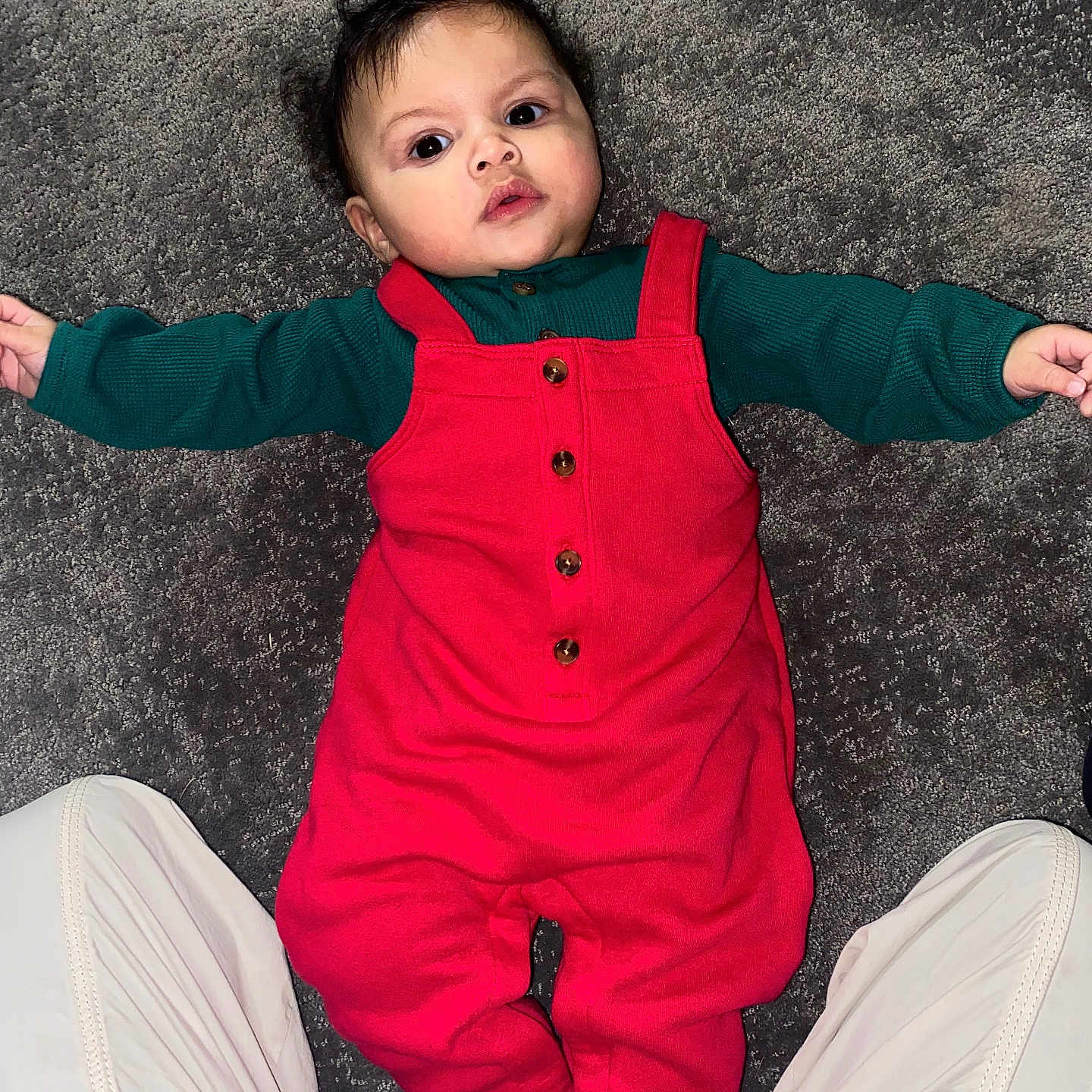 Braxton joined the competition — help win amazing prizes! baby, infant, red_overall, green_sleeves, carpet, floor, person, child, cute, lying_down, indoor, portrait, face, hands, feet, clothing, young_child, casual, human, baby_girl