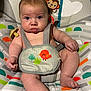 baby, infant, face, eyes, chubby_cheeks, bouncer_seat, seat_harness, pacifier, toy_monkey, patterned_fabric, legs, arms, mouth, skin, expression, indoor, closeup, cute, child, seat