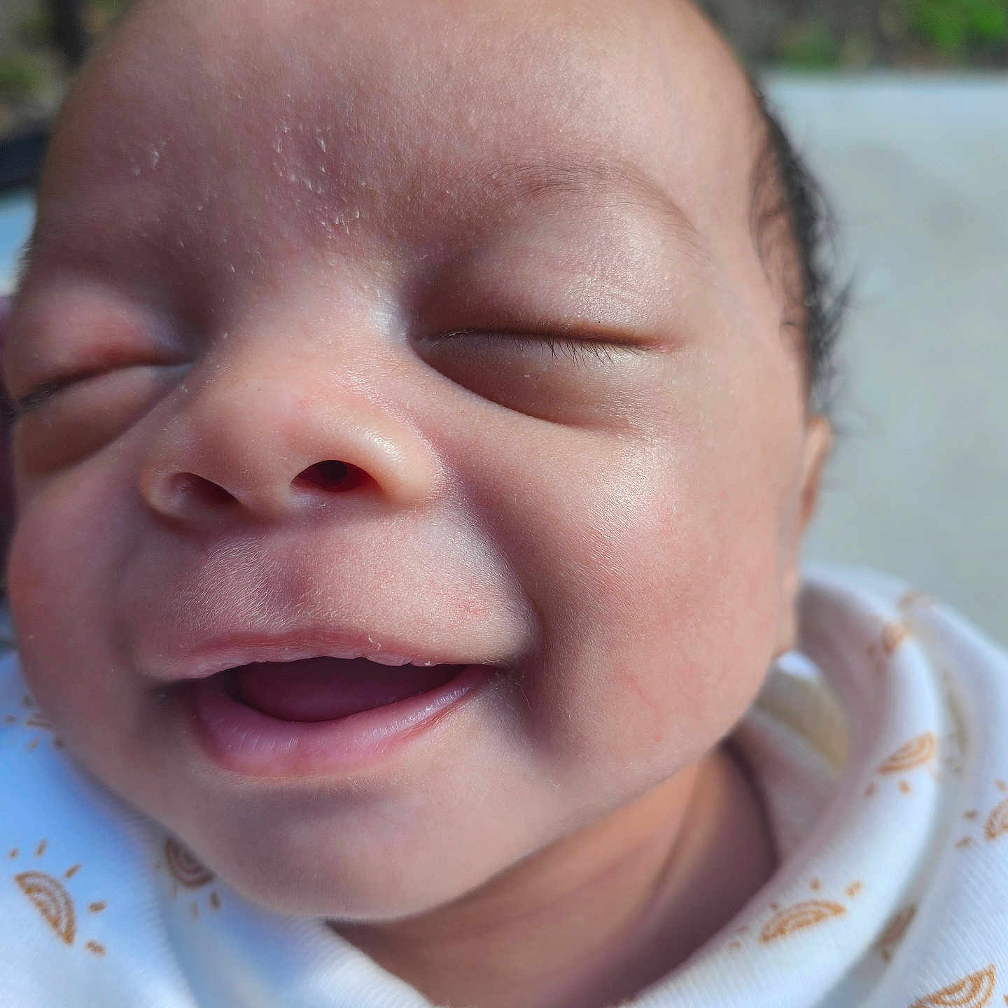 Ba'Jaih joined the competition — help win amazing prizes! baby, closeup, clothing, cute, expression, eyes_closed, face, happy, head, infant, natural_light, outdoor, pattern, peaceful, portrait, skin, small, smiling, white_garment, young_child