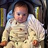 baby, infant, child, car_seat, portrait, sitting, wide_eyed, face, eyes, blanket, onesie, clothing, animal_print, car, safety_label, indoor, closeup, photography, cute, person