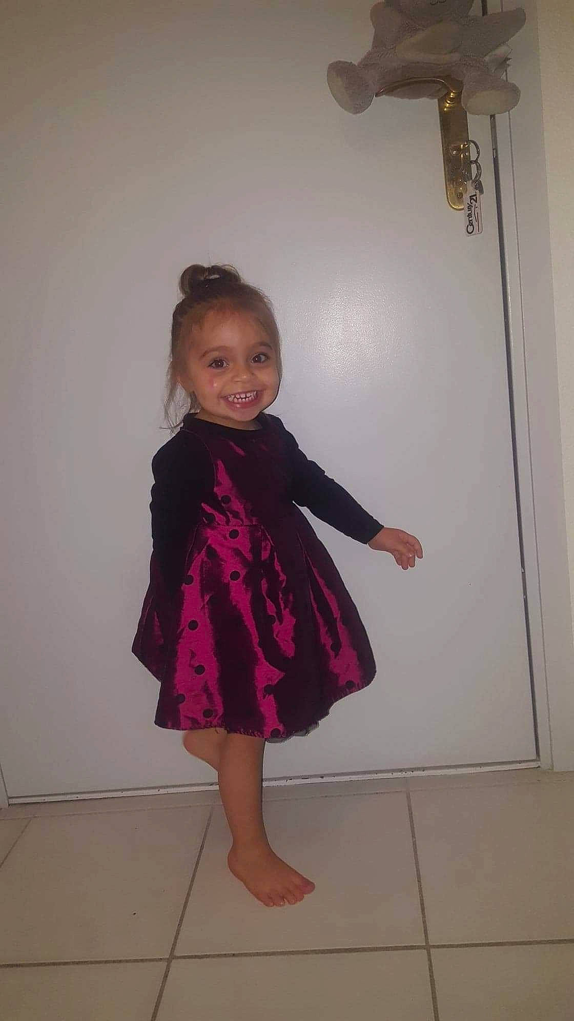 Julia participe au concours pour gagner de l'argent avec cette photo : baby_toddler_clothing, child, day_dress, dress, fashion_design, floor, flooring, formal_wear, fun, human_leg, joy, magenta, one_piece_garment, pattern, person, pink, room, sleeve, smile, toddler