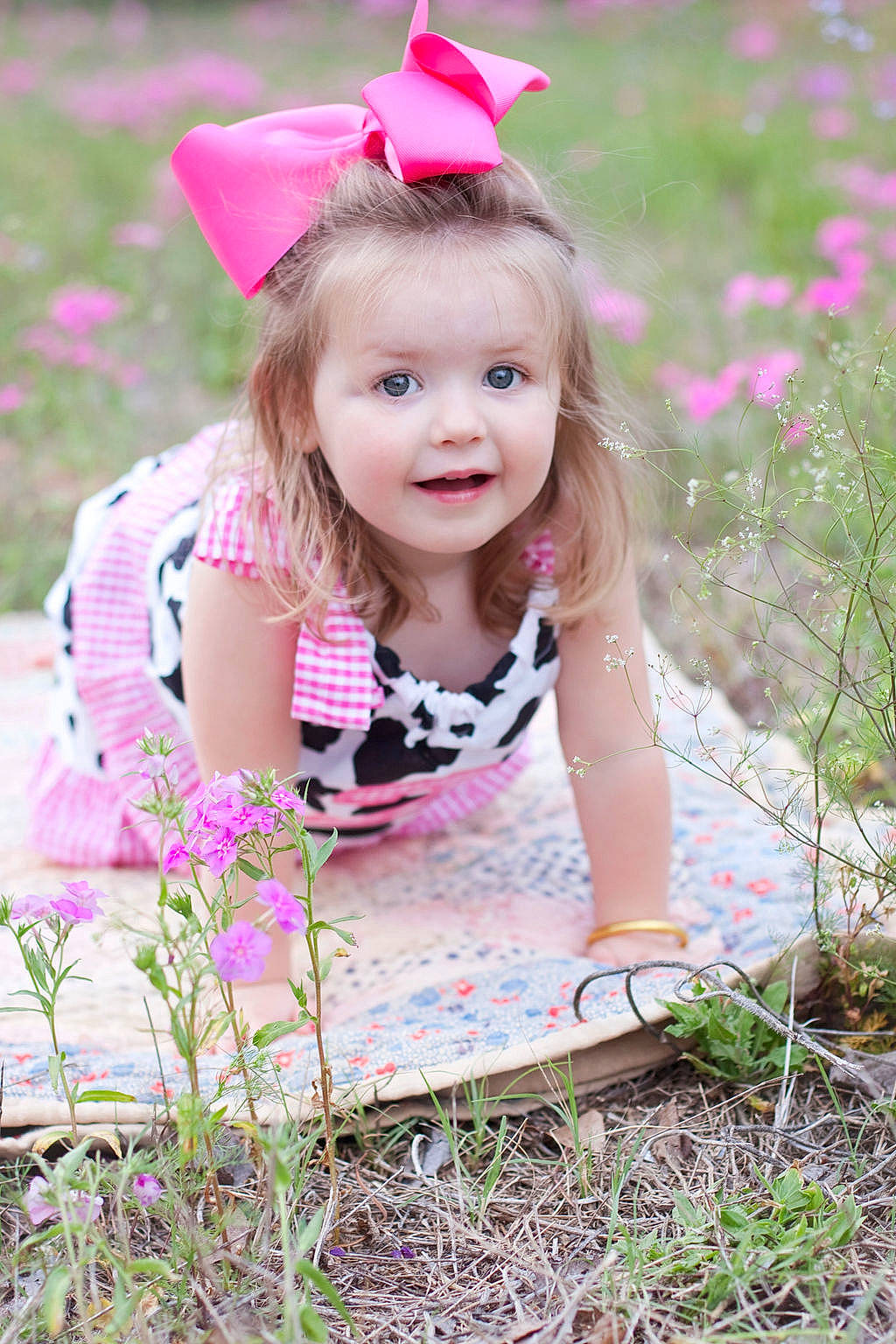 Anna is registered to the contest to win money with this photo: baby_toddler_clothing, botany, child, eye, face, facial_expression, fawn, flower, grass, hairstyle, happy, joy, people_in_nature, person, petal, pink, plant, purple, skin, smile
