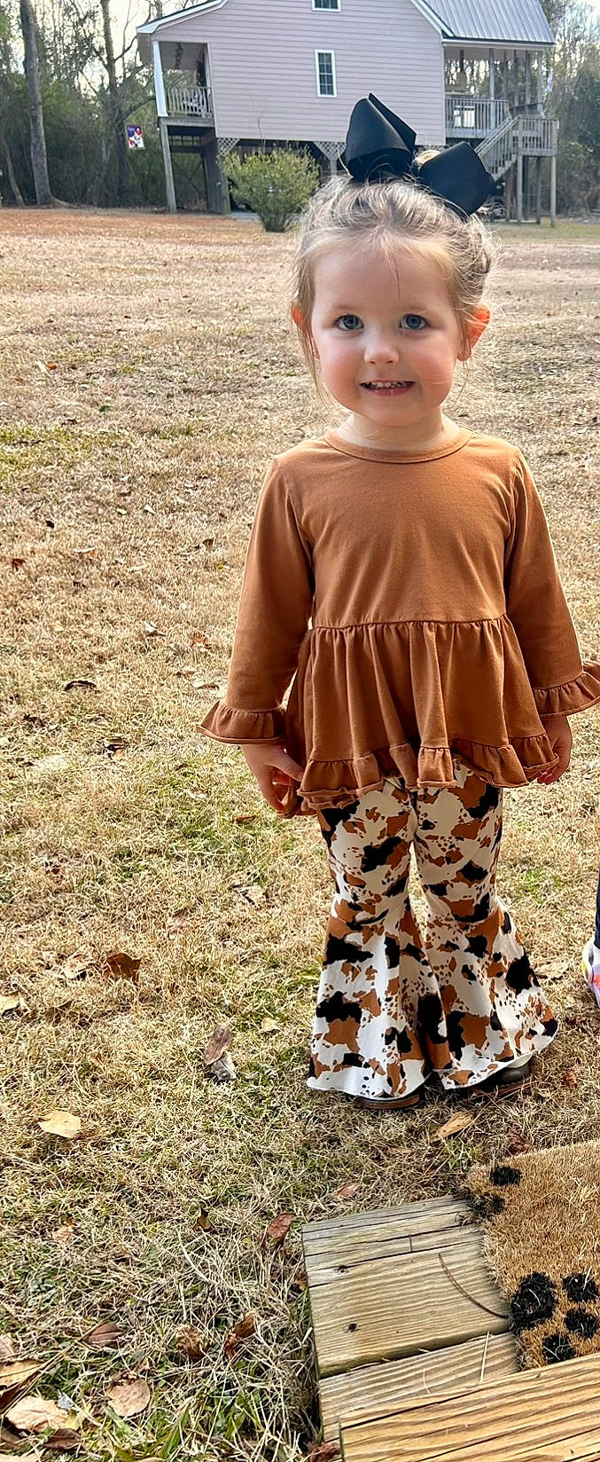 Anna is registered to the contest to win money with this photo: baby_toddler_clothing, child, day_dress, face, grass, happy, head, human_leg, joy, knee, leggings, pattern, people_in_nature, person, sitting, sleeve, smile, soil, t_shirt, toddler