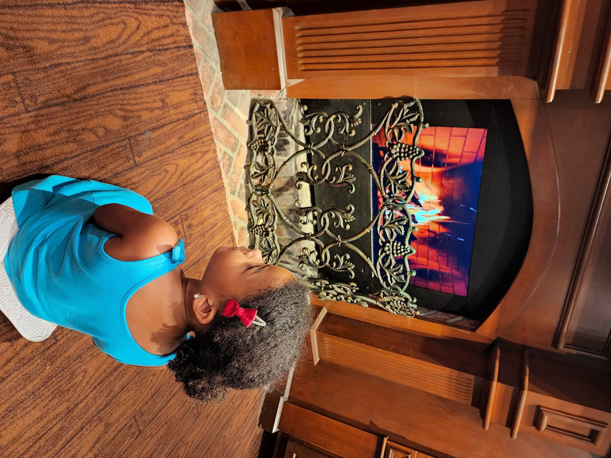 Olivia is registered to the contest to win money with this photo: abdomen, art, display_device, elbow, flooring, fun, hardwood, hat, human_leg, leisure, living_room, machine, person, room, sitting, sunglasses, television_set, thigh, trunk, visual_arts