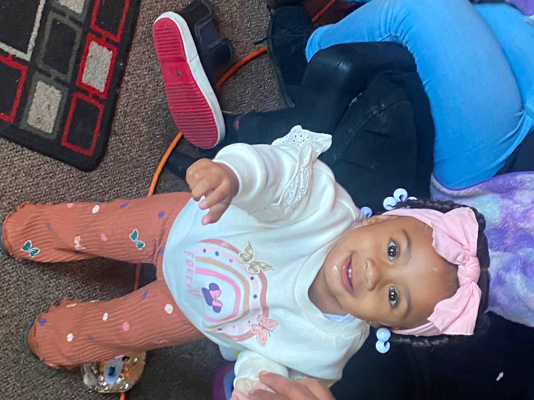 Reign is registered to the contest to win money with this photo: baby_products, bag, carmine, cheek, child, foot, fun, gesture, happy, hat, headwear, human_leg, joy, lap, leisure, luggage_and_bags, pattern, person, plaid, sitting