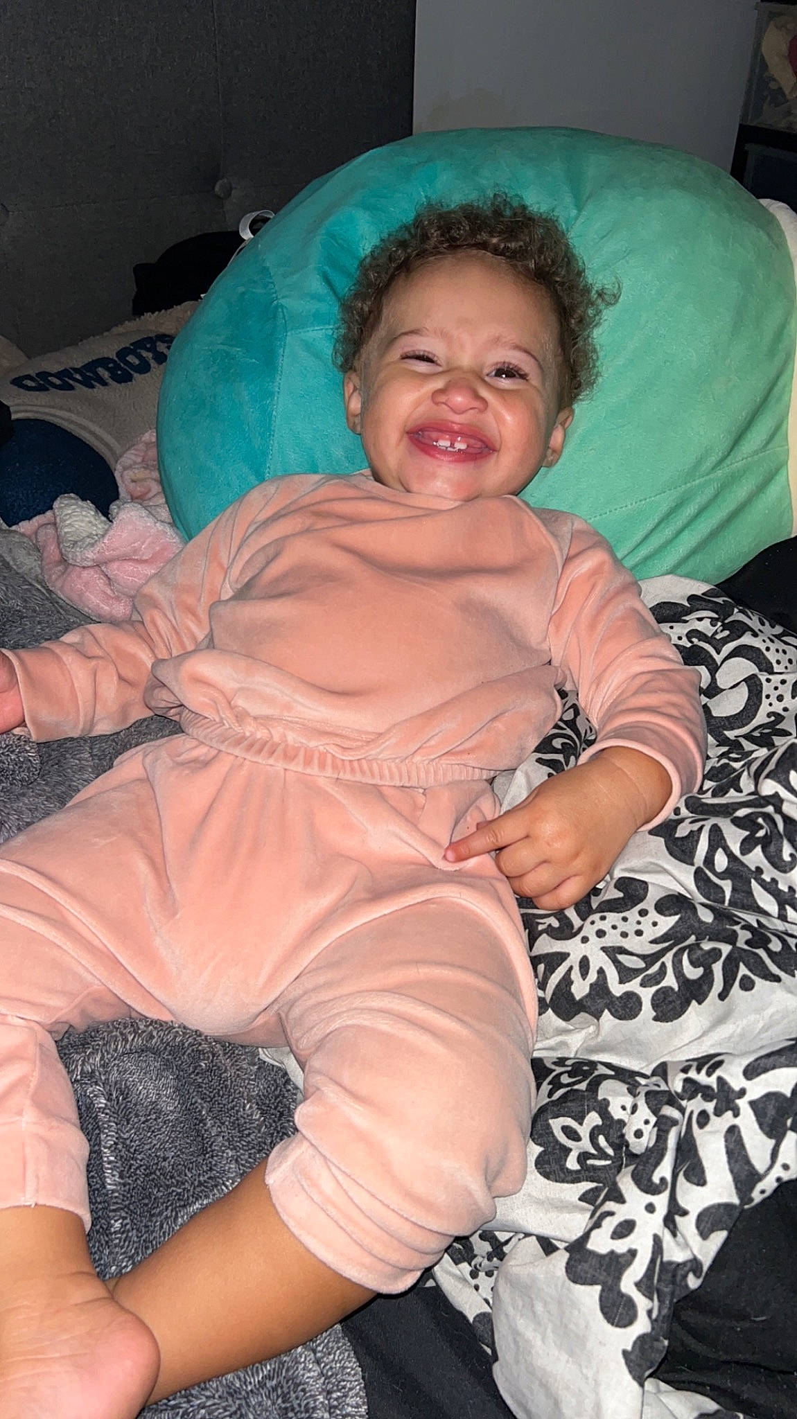 Eden is registered to the contest to win money with this photo: abdomen, arm, chest, comfort, elbow, event, eye, finger, happy, human_body, human_leg, joint, joy, lap, linens, mouth, person, pink, smile, textile