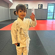 May-Linh participe au concours pour gagner de l'argent avec cette photo : child, judo, martial_arts, dojo, karate_gi, white_belt, barefoot, smile, waving, indoor, sport, young_child, training, mat, portrait, cute, happy, person, activity, gym