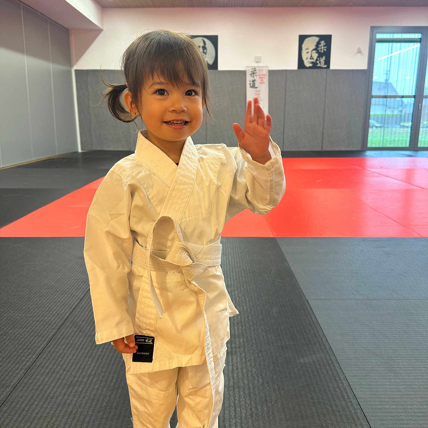 May-Linh participe au concours pour gagner de l'argent avec cette photo : activity, barefoot, child, cute, dojo, gym, happy, indoor, judo, karate_gi, martial_arts, mat, person, portrait, smile, sport, training, waving, white_belt, young_child