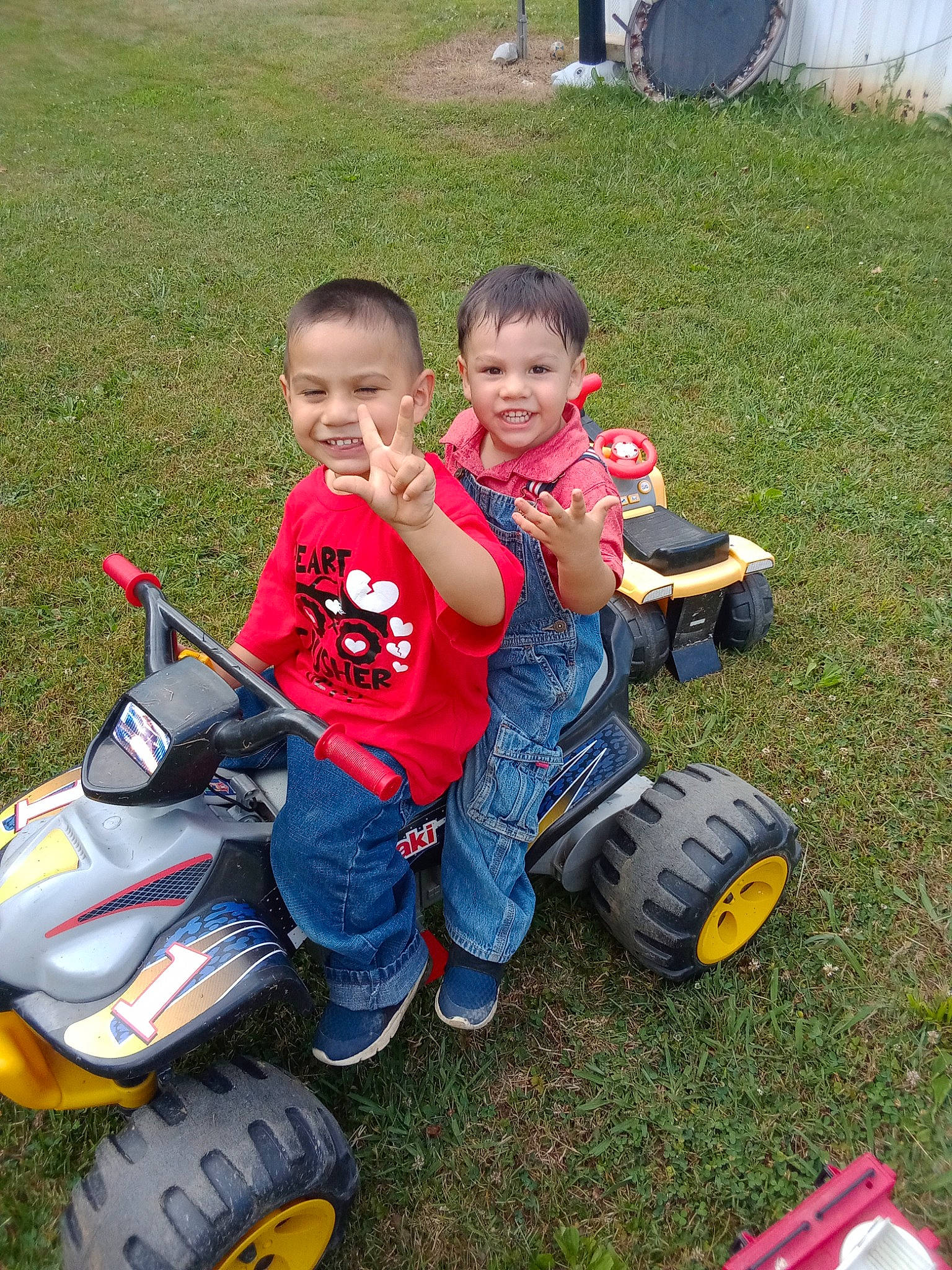 Michael is registered to the contest to win money with this photo: automotive_tire, face, fun, grass, happy, jeans, joy, lap, lawn, motor_vehicle, person, riding_toy, sharing, shoe, sitting, smile, sneakers, tire, toddler, toy