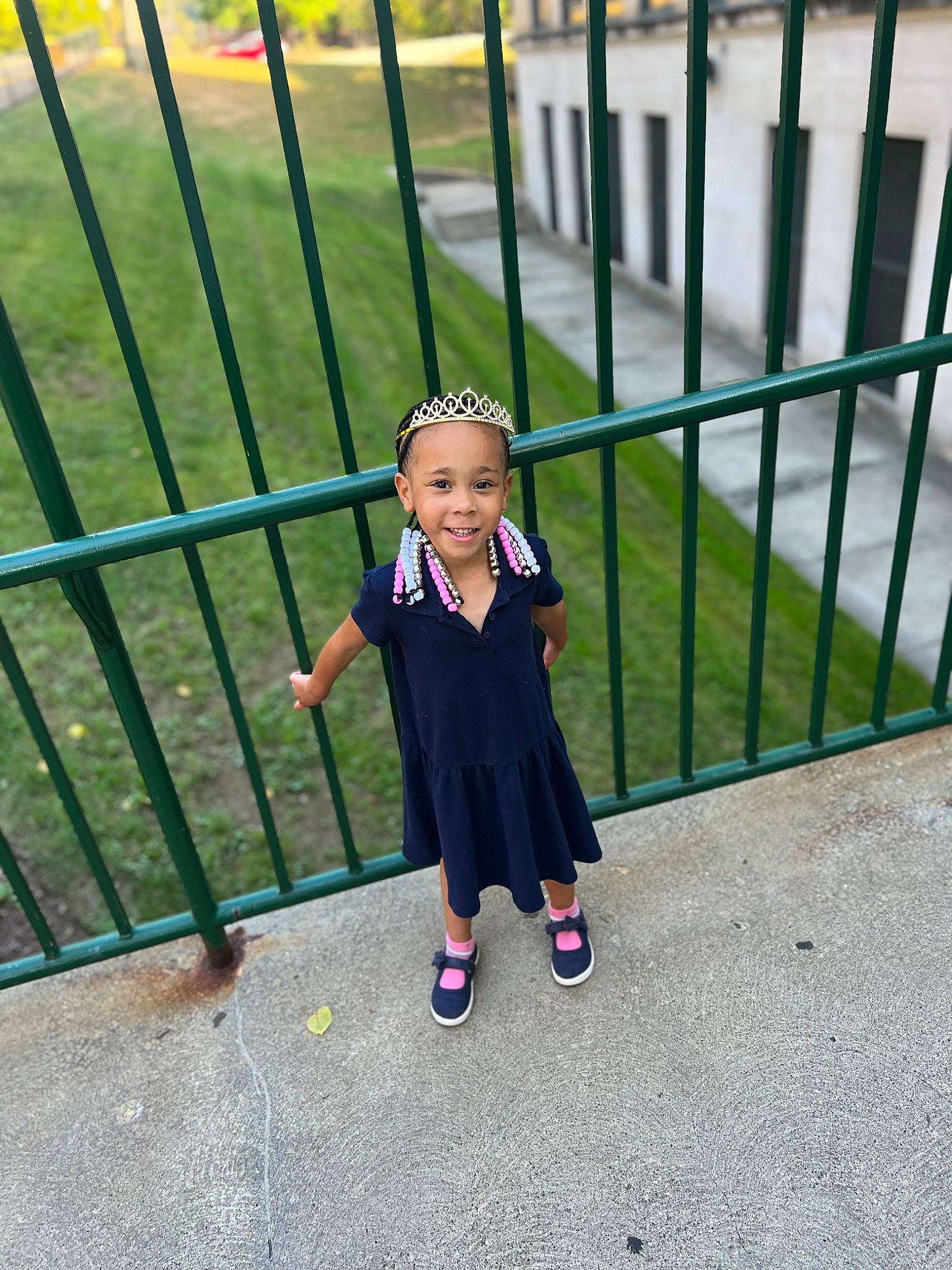 Madisyn is registered to the contest to win money with this photo: baby_toddler_clothing, child, city, electric_blue, face, fence, fun, grass, happy, hat, joy, leisure, magenta, metal, pattern, person, recreation, sidewalk, smile, toddler