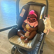 Nyziah joined the competition — help win amazing prizes! accessory, baby, baby_carrier, child, clothing, cute, floor, flower, footwear, headband, indoor, infant, pink, plush_unicorn, relaxing, seat, stroller, sunglasses, toy, wooden_floor