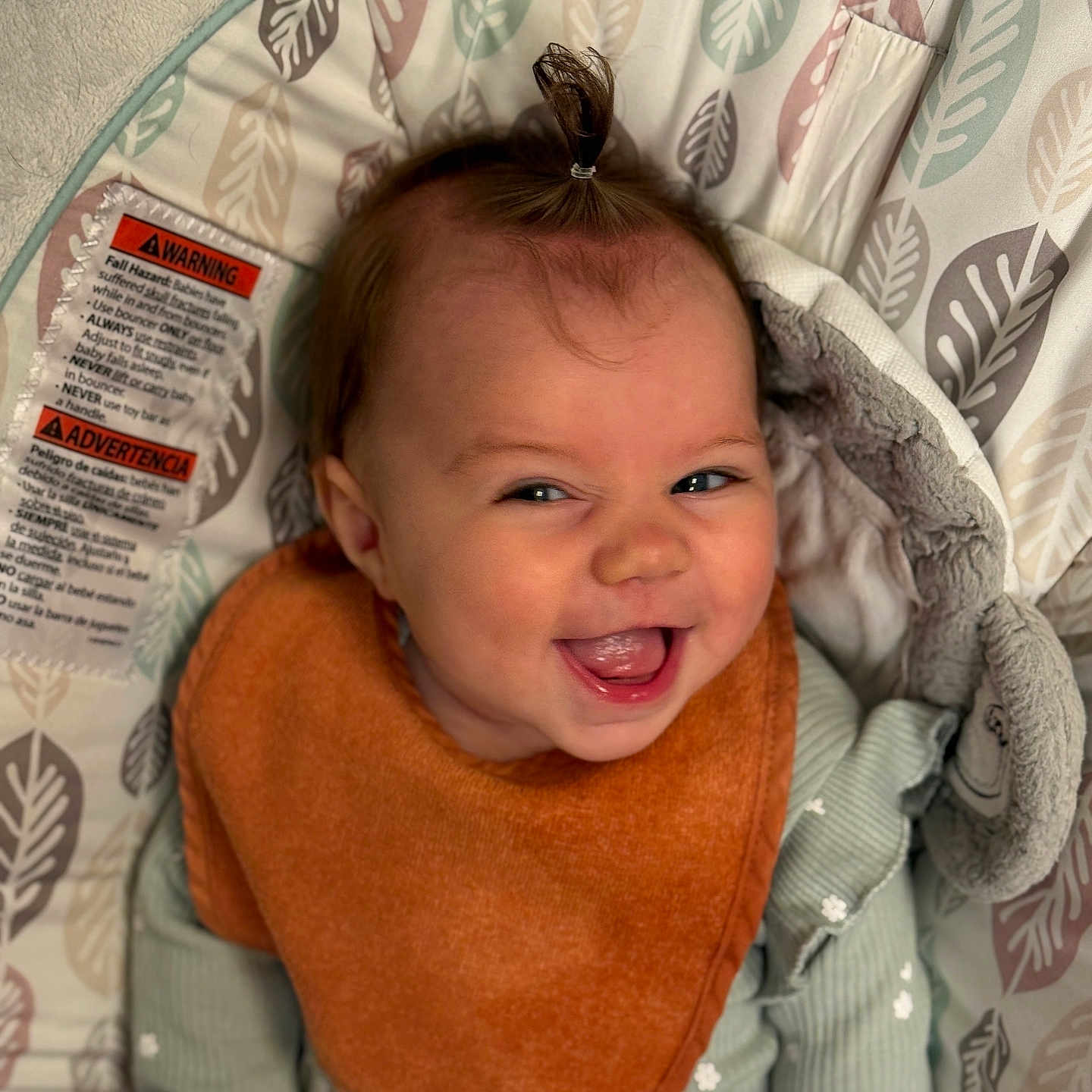 Nikiya is registered to the contest to win money with this photo: apparel, baby, baby_seat, bib, child, cozy, cute, expression, face, green_clothing, happy, indoor, infant, joyful, leaf_pattern, ponytail, portrait, sitting, smiling, soft_toys